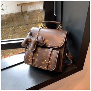 Gros plan d'un sac à dos marron rétro avec monogramme ours et détails en cuir texturé
