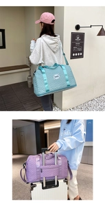 Detail of large quilted travel bag showing trolley sleeve for luggage attachment