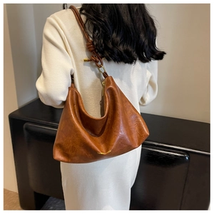 Detail of dark brown Hobo bag with knot shoulder strap and golden ring metal hardware