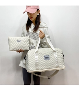 Detail of cream quilted travel bag set featuring a large tote and matching clutch bag