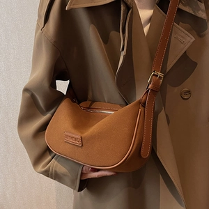 Caramel suede hobo shoulder bag with leather trim and adjustable strap shown on model