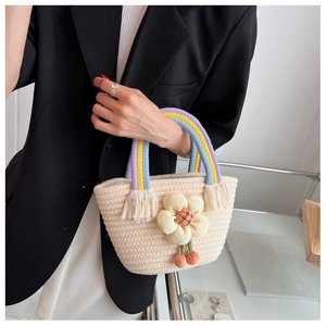 Gros plan du sac seau tissé avec anses arc-en-ciel et une grande fleur jaune en 3D