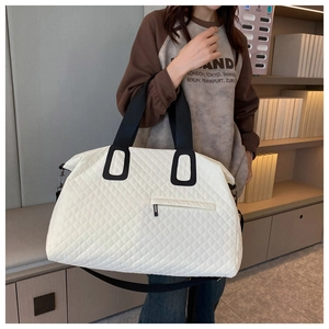 Close-up of white quilted travel bag with large capacity and detachable strap