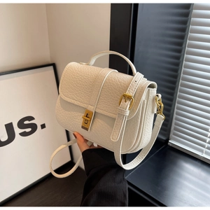 Detail of white lychee texture leather with vintage gold twist lock and handle
