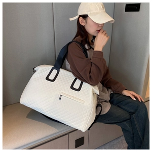 Detail of the large quilted travel bag showing diamond pattern and contrast straps