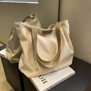 Minimalist off-white large capacity canvas tote bag with brown leather handles and detail