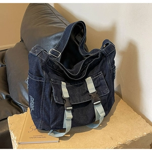 Gros plan détaillé du sac fourre-tout en denim foncé avec coutures blanches et boucles