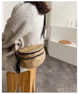 Close-up of khaki nylon crescent bag with dual zippers and Fashion letter straps