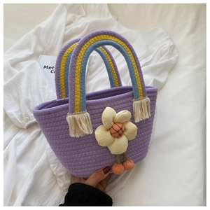 Dettaglio della borsa in cotone intrecciato viola con decoro floreale e frange arcobaleno