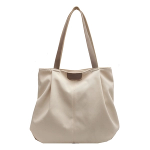 Minimalist beige canvas bucket tote bag with brown leather handles and brand detail