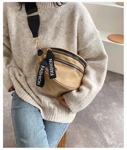 Detail of khaki nylon crescent bag with dual zippers and branded fashion pullers