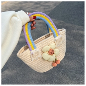 Détail du sac seau tissé à la main blanc cassé avec anses arc-en-ciel et fleur 3D