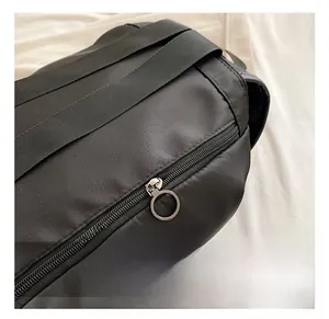 Detail showing high-density nylon fabric texture and circular metal zipper pull on black backpack