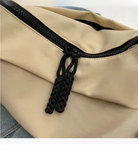 Detail of smooth double-way black zipper and woven puller on beige nylon tote bag