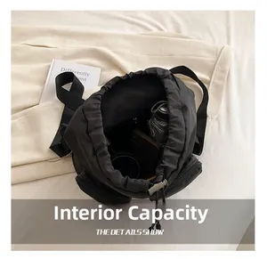 Detail showing high-capacity interior of black oxford backpack with drawstring closure