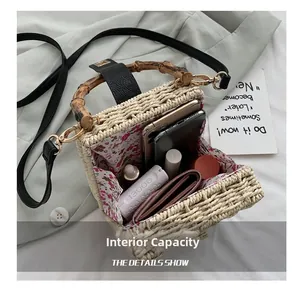 Detail of woven straw box bag showing spacious floral interior with everyday essentials