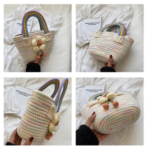 Dettaglio borsa in paglia colorata con decori floreali 3D e manico arcobaleno con frange