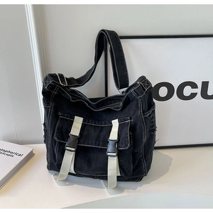 Détail du sac fourre-tout en toile noire avec coutures contrastées blanches et sangle