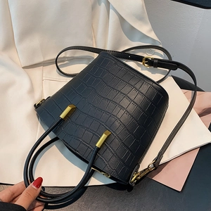 Elegant black crocodile embossed leather bucket bag with gold hardware and shoulder strap
