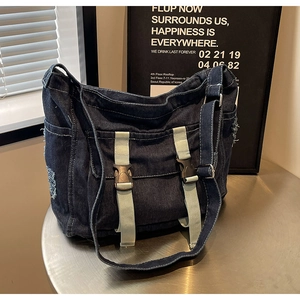 Détails de sac cabas en denim bleu foncé avec texture usée et sangles à boucle décoratives
