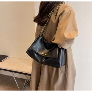 Détail du sac hobo noir avec bandoulière en chaîne dorée et cuir texturé