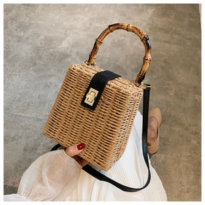 Detailed macro view of straw woven bag with bamboo handle and gold metal lock