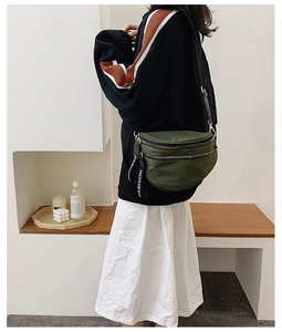 Detail of dark green crescent nylon bag with adjustable strap and fashion logo webbing