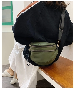Dark green leather crescent waist bag with double zippers and wide black strap