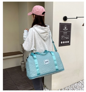 Detail of teal quilted large capacity travel bag with thick straps and shoe compartment