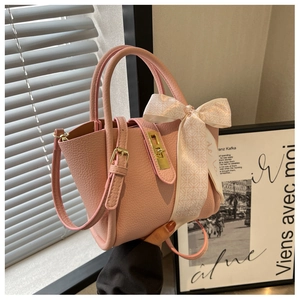 Detailed macro of pink lychee leather handbag featuring decorative floral silk scarf and gold lock