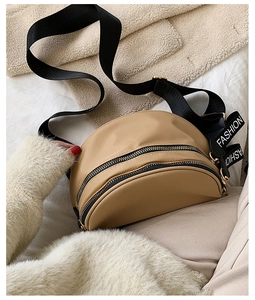 Detail of khaki crescent crossbody bag with double zippers and fashion letter strap