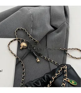 Détail du sac en cuir matelassé noir avec boule en métal réglable dorée et bandoulière