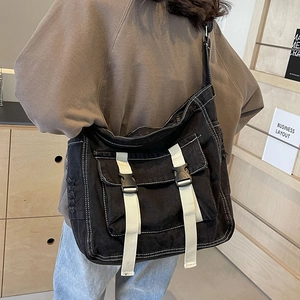 Sac fourre-tout en toile noire avec surpiqûres et bandoulière sur le mannequin