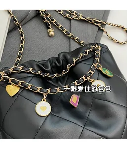 Détail du sac seau en cuir noir matelassé avec breloques cœurs émaillés sur la chaîne