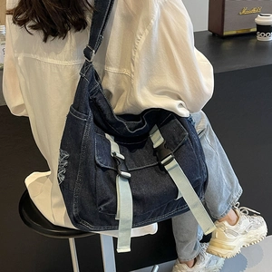 Grand sac messager en denim bleu foncé avec détails usés et large bandoulière