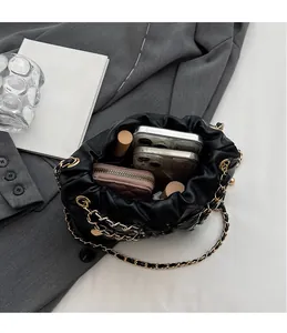 Vue intérieure d'un sac seau noir matelassé montrant le rangement des accessoires