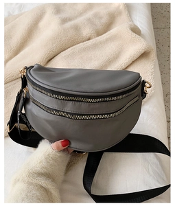 Detail of grey nylon half-moon crossbody bag with golden zippers and FASHION strap