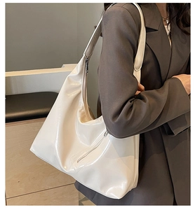 Detail of cream white high-gloss leather tote bag with silver zipper and large capacity