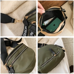 Detail view of nylon crossbody bag with dual zip compartments and fashion strap
