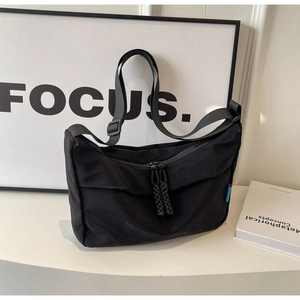Detail of minimalist black hobo bag with adjustable strap and rope zipper pullers