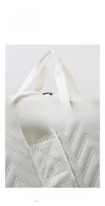 Detail of reinforced stitching and ergonomic handles on the large quilted travel bag