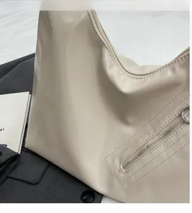 Detail of soft beige leather tote featuring vintage wrinkled texture and metal zipper