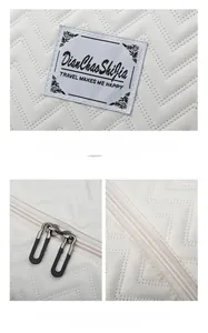 Detail of quilted travel bag featuring woven logo patch and dual metal zipper closure