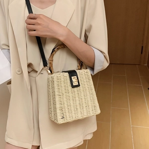 Handwoven straw crossbody bag with bamboo handle and elegant golden metal twist lock