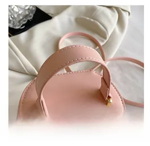 Detail of soft pink faux leather bag with wide comfortable handle and golden D-ring