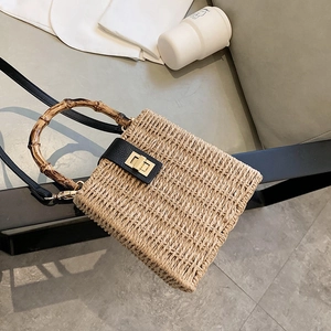 Handmade woven straw handbag with bamboo top handle and leather strap for women