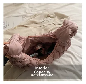 Innenkapazität der rosa gesteppten Croissant-Tasche mit Make-up-Artikeln darin