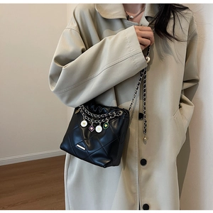 Détails du sac seau noir matelassé avec bandoulière chaîne et breloques en émail coloré