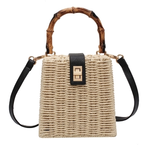 Handmade straw handbag with bamboo handle, leather trim and golden twist lock closure