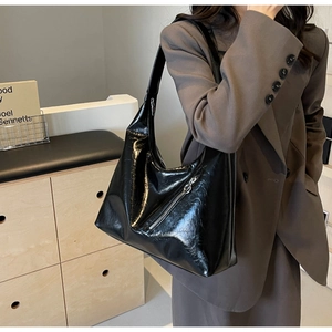 Detail of black faux leather tote with decorative zipper and wide shoulder strap